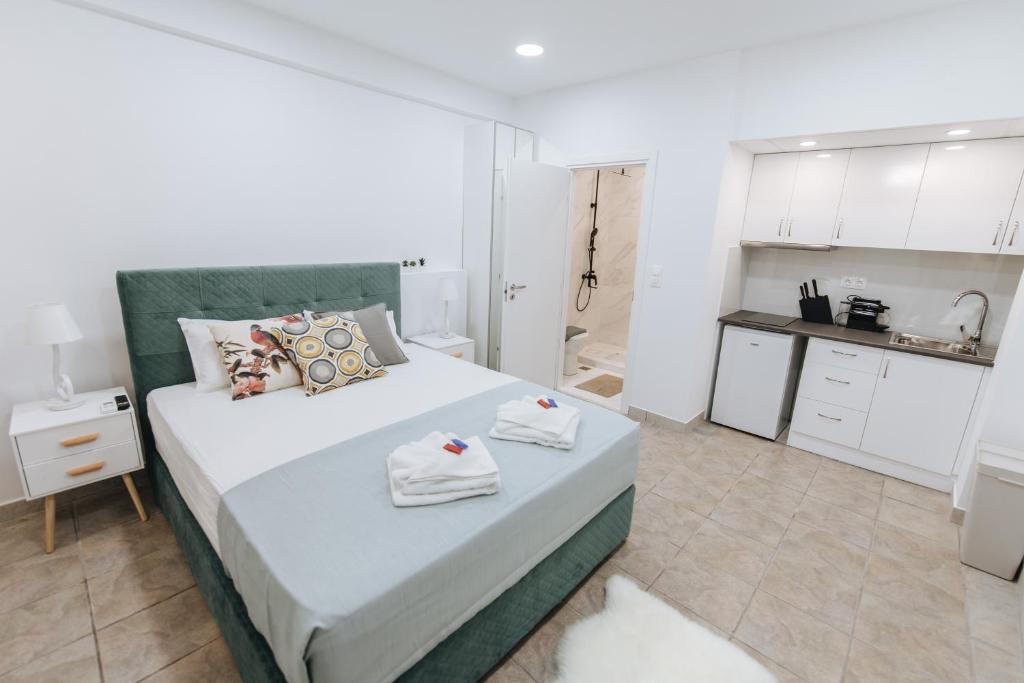 a bedroom with a large bed with towels on it at Your Cozy Sapphire Apartment in Athens