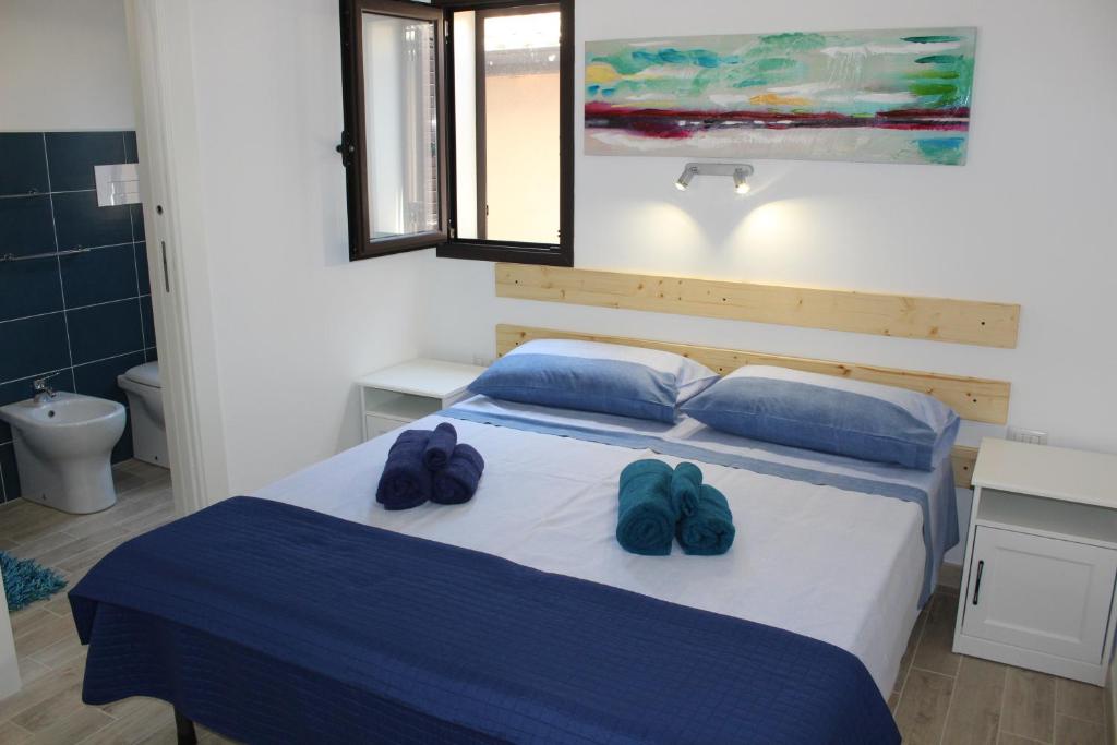 a bedroom with a bed with two blue flip flops on it at Anthiros Affitti brevi in Arenella