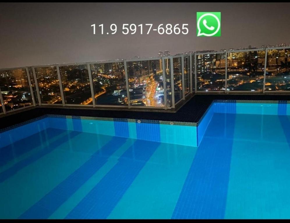 een foto van een zwembad met een skyline van de stad bij Terraço Harmony Flats GRU in Guarulhos