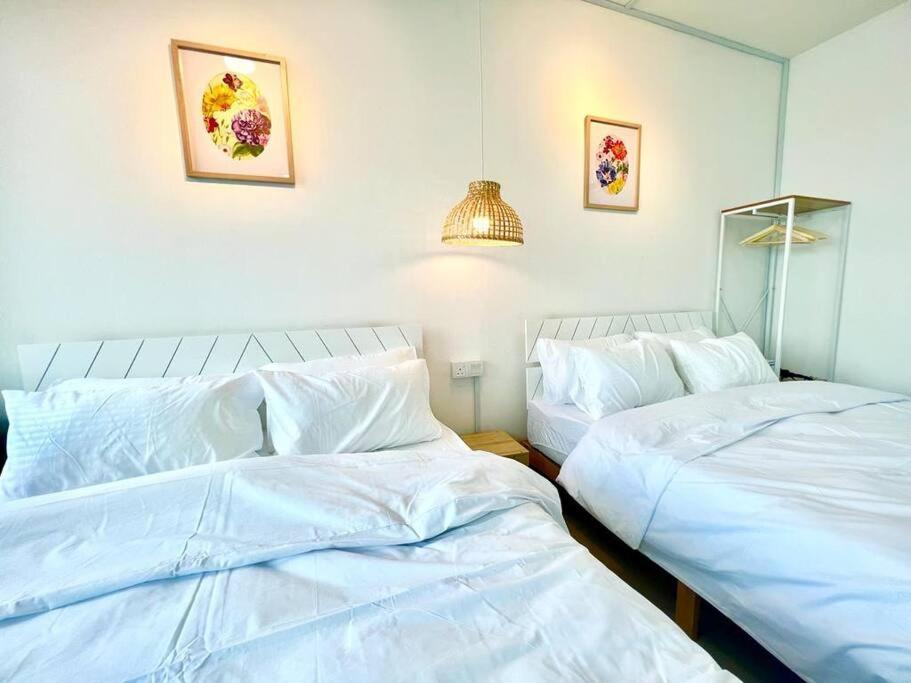 two beds sitting next to each other in a bedroom at B Setia Alam 1-5 Pax Cozy Home Wifi&TV Studio 3 Beds Trefoil Shah alam in Shah Alam