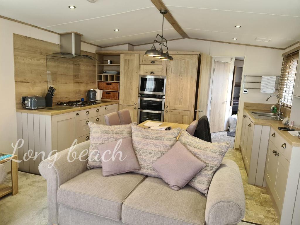 a living room with a couch in a kitchen at Luxury holiday lodge Lyons Robin Hood Rhyl Wales in Rhyl