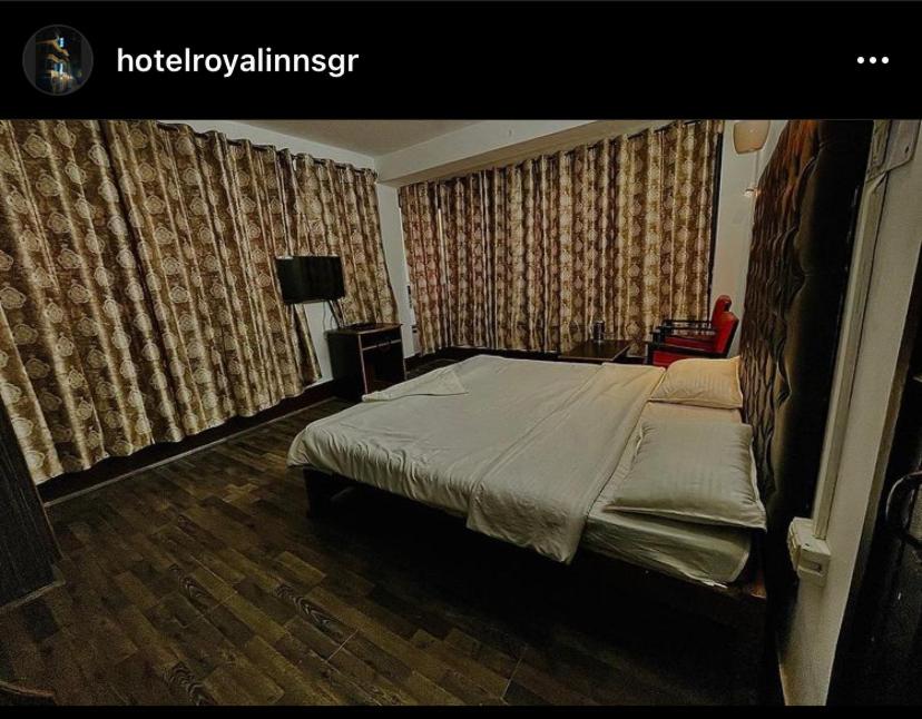 een slaapkamer met een bed in een kamer met gordijnen bij Hotel Royal inn and restaurant in Srinagar