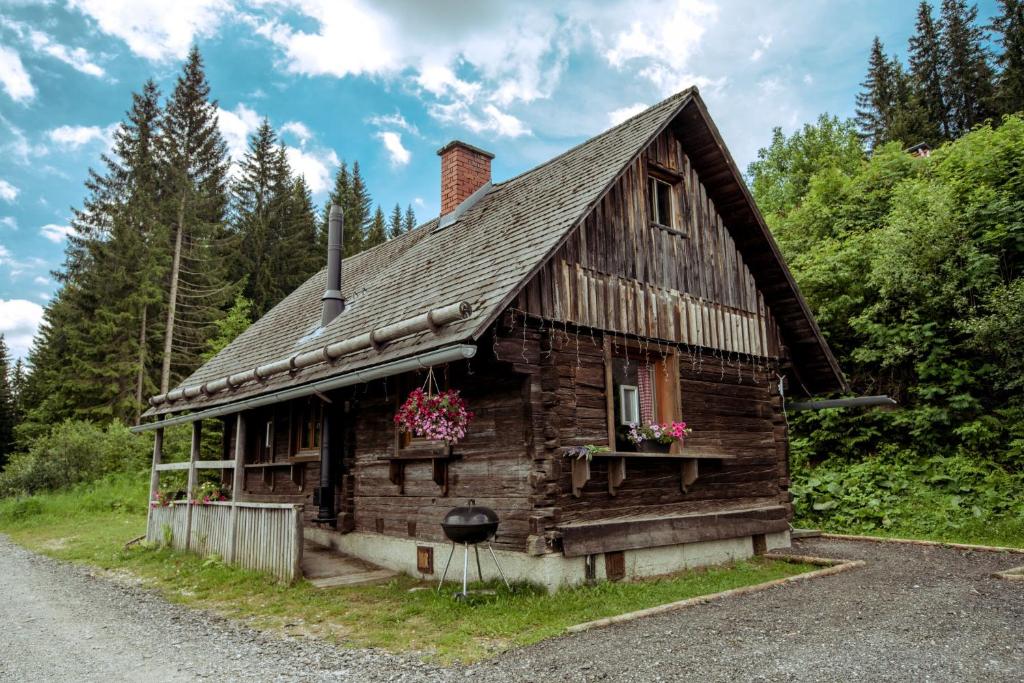 une vieille maison en bois sur le côté d'une route dans l'établissement Almhütte Hebalm, à Pack