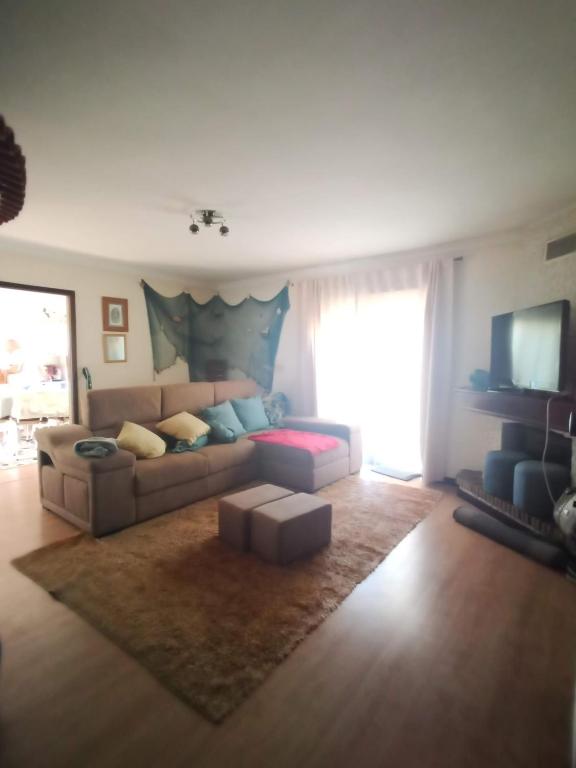 a living room with a couch and a television at Apartamento T3 Furadouro in Ovar