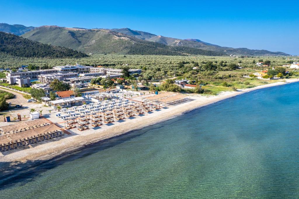 - une vue aérienne sur une plage dotée de chaises et de parasols dans l'établissement ALEA Hotel & Suites, à Prinos