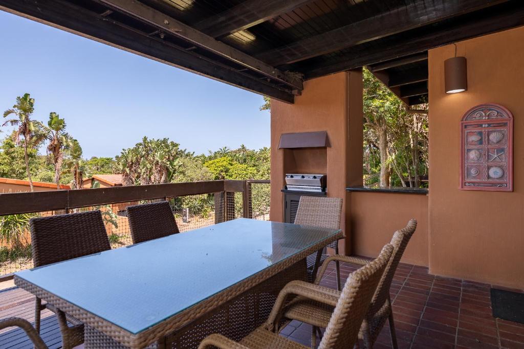 een terras met een tafel en stoelen bij San Lameer Villa 2851 - 2 Bedroom Classic - 4 pax - San Lameer Rental Agency in Southbroom