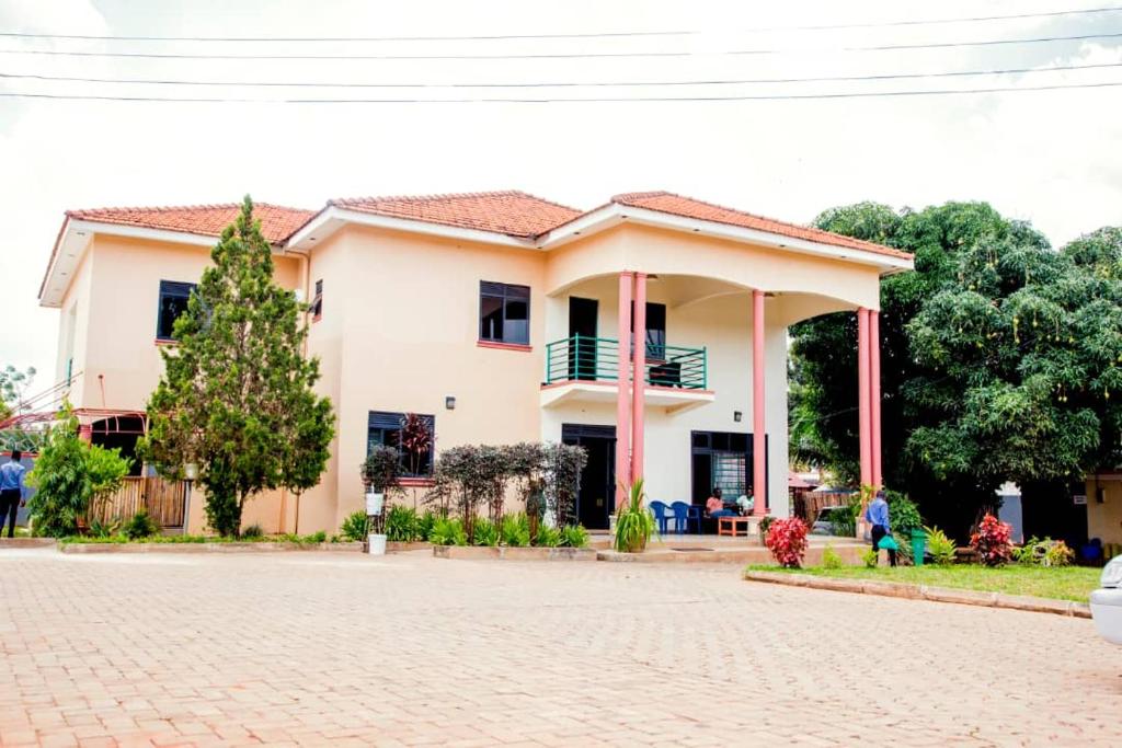 uma casa com uma estrada de tijolos em frente em Jojo's Palace Annex em Gulu
