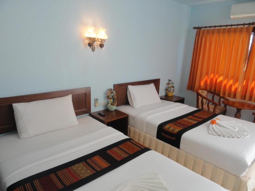 a hotel room with two beds and a window at Vacation House in Klong Muang Beach