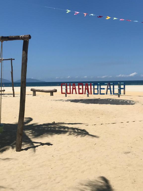 a sign on the beach with a bench on the beach at Hoi An beach house in Hoi An