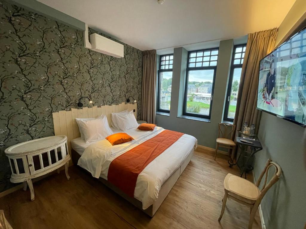 um quarto com uma cama grande e uma televisão em Hôtel Maison Demelenne em Hotton