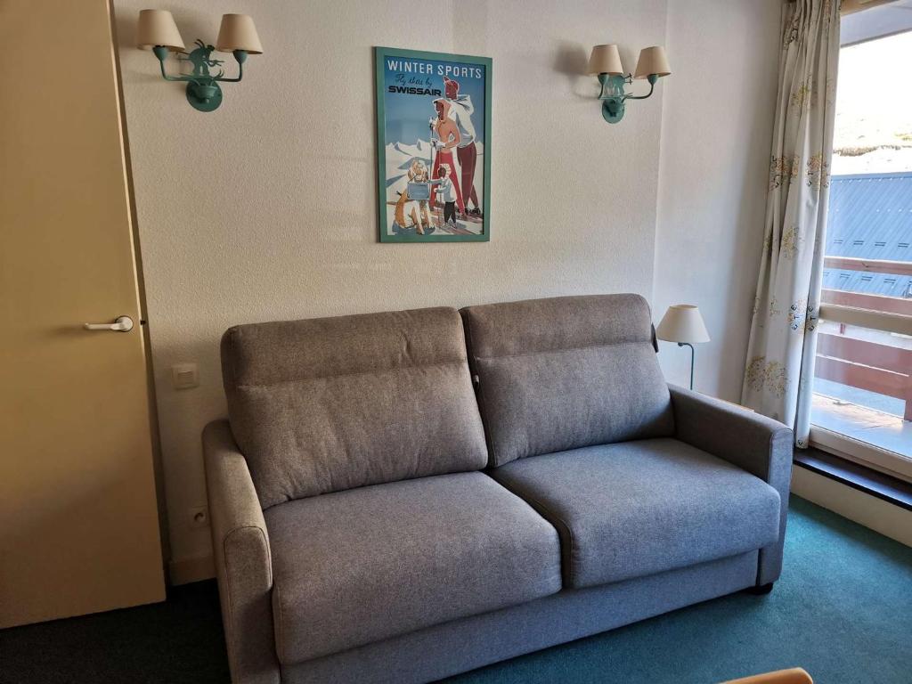 uma sala de estar com um sofá e um poster de um filme em Appartement La Mongie, 2 pièces, 6 personnes - FR-1-404-115 em La Mongie
