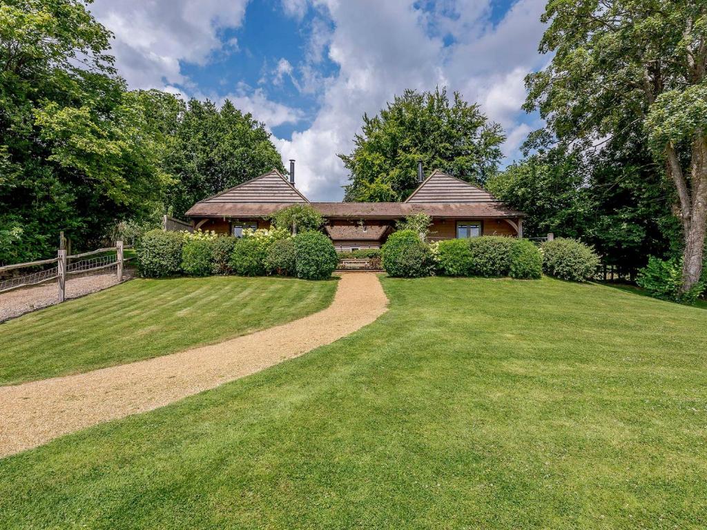 a house with a grassy yard in front of a house at Castlemans Stables East in Sedlescombe