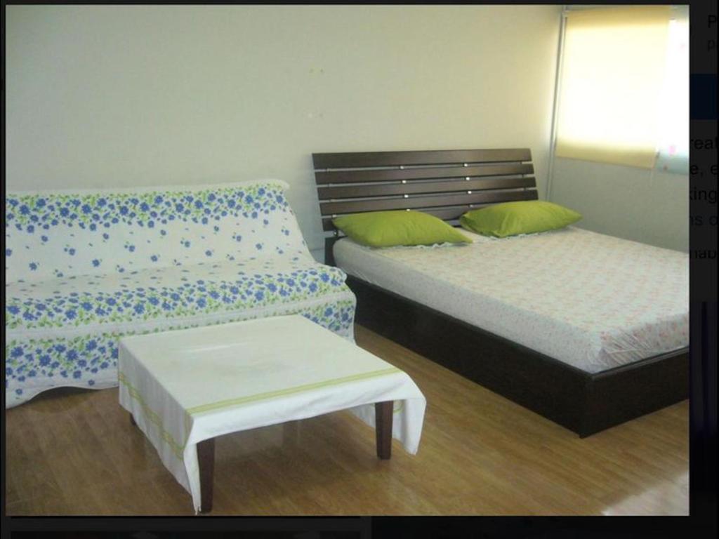 um quarto com duas camas e um banco e uma mesa em Thailand Taxi Apartment Hostel em Thung Si Kan