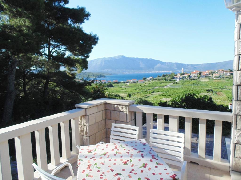 a table and two chairs on a balcony with a view at VILLA Apartments Mate Cebalo in Lumbarda