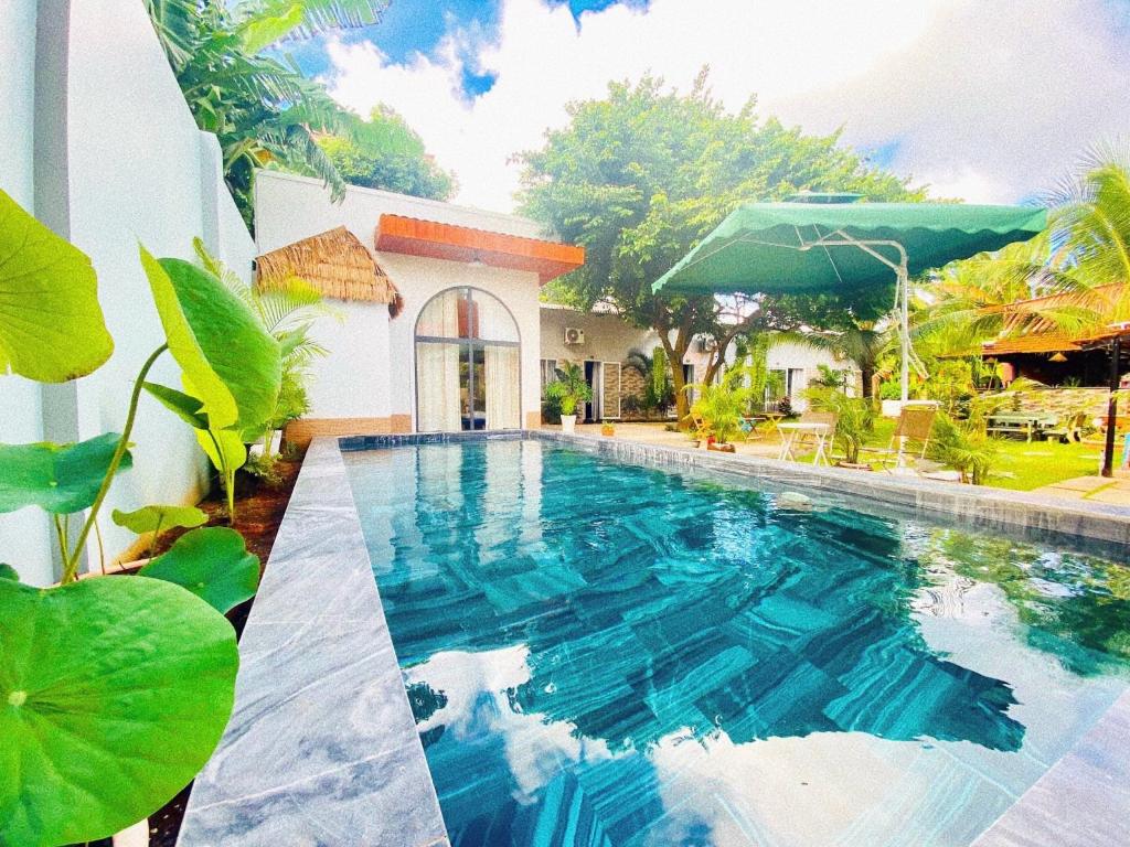 a swimming pool in front of a house at Hồ Cốc Homestay in Ho Coc