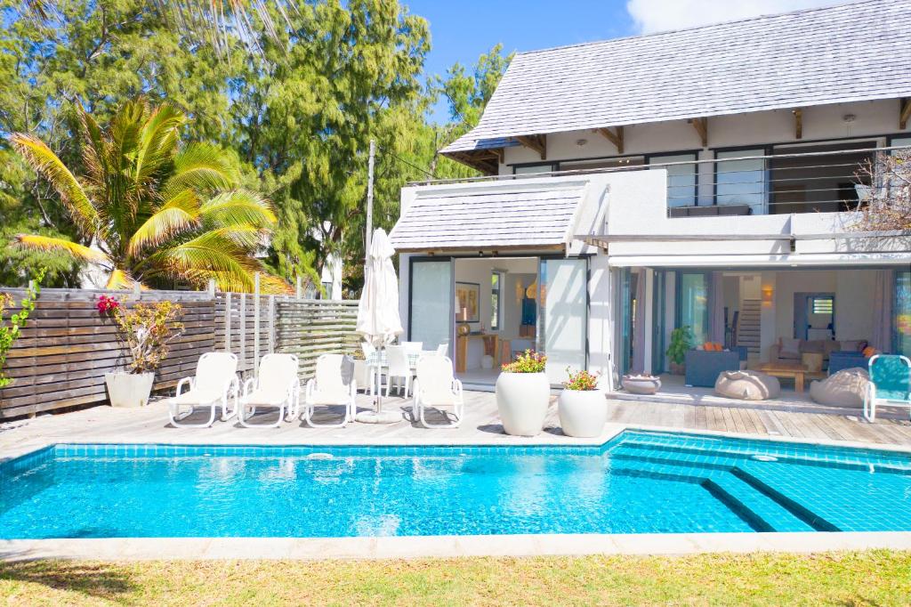 a swimming pool in front of a house at Peter's Beach House in Poste Lafayette