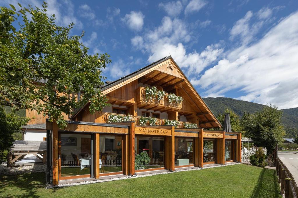 a house with glass windows and a roof at Hotel Lipa in Kranjska Gora