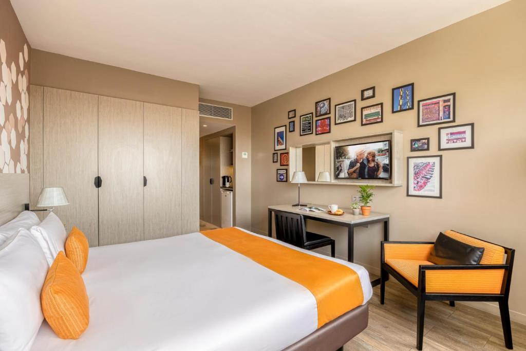 a hotel room with a bed and a desk at Citadines Ramblas Barcelona in Barcelona