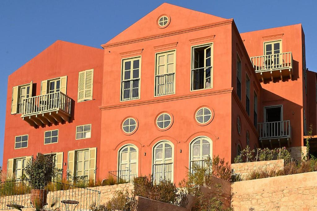 an orange building with two balconies on the side of it at Casa Mediterraneo Hotel in Meyisti