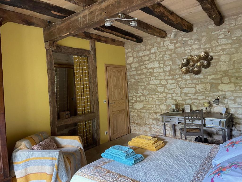 a bedroom with a bed and a table in a room at Domaine de Galoubet Lot in Beaumat