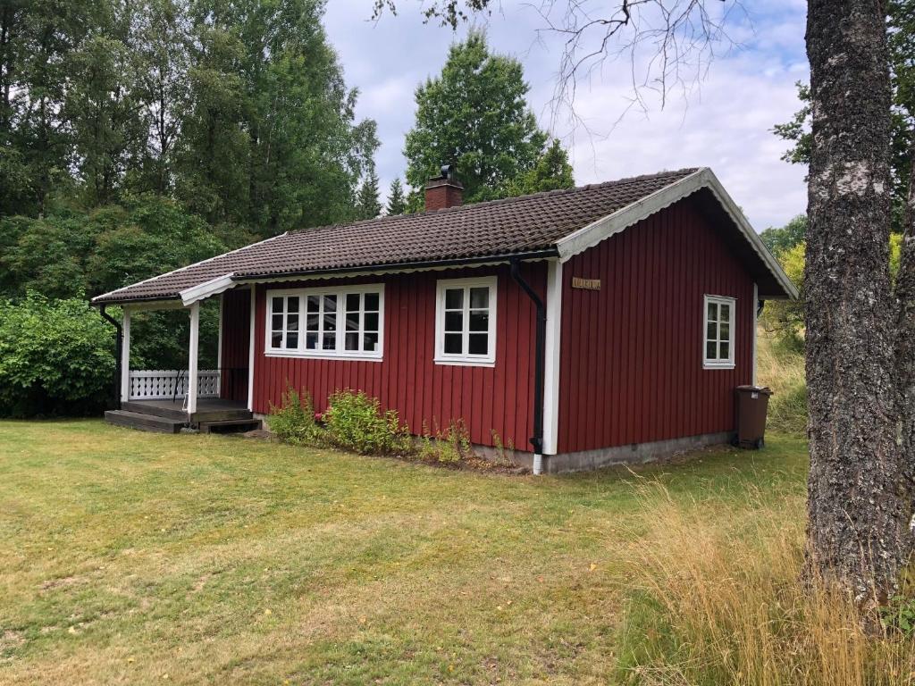 una casa roja con ventanas blancas en un patio en Sävekulla 208 "Lillekulla", en Sävekulla