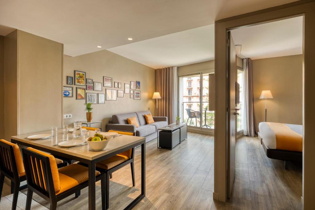 a hotel room with a dining table and a living room at Citadines Ramblas Barcelona in Barcelona