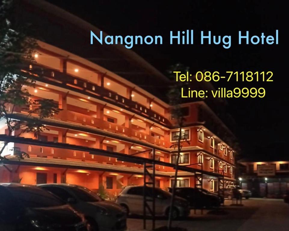 un grand bâtiment avec des voitures garées devant lui dans l'établissement Nangnon Hill Hug Hotel, à Ban Pa Muat