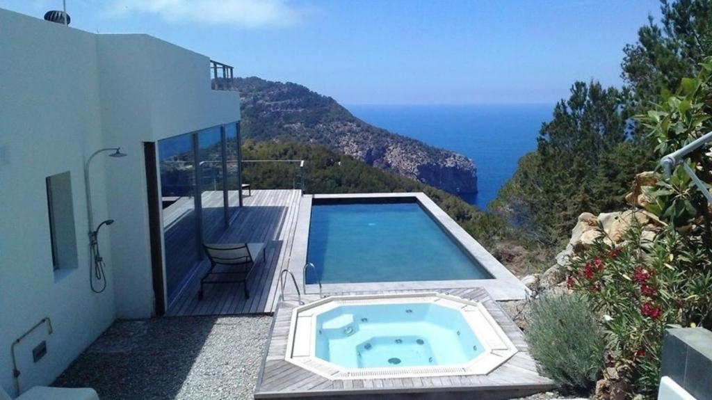 a swimming pool on the side of a house at Design Studio Cap Rubio Ibiza in Na Xamena