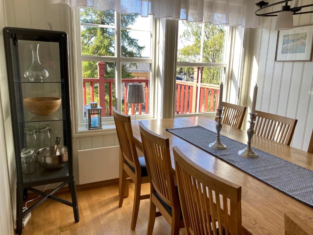 a dining room with a table and chairs and windows at Åre Travel - Åre Park in Åre