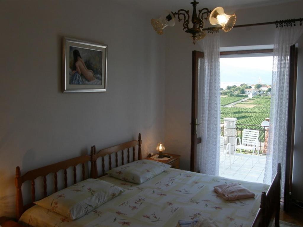 a bedroom with a bed and a large window at VILLA Apartments Mate Cebalo in Lumbarda