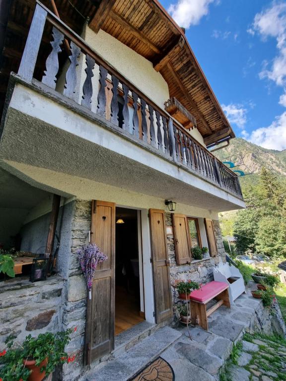 a house with a balcony and a wooden door at CASA NONNA RINA in Alagna Valsesia