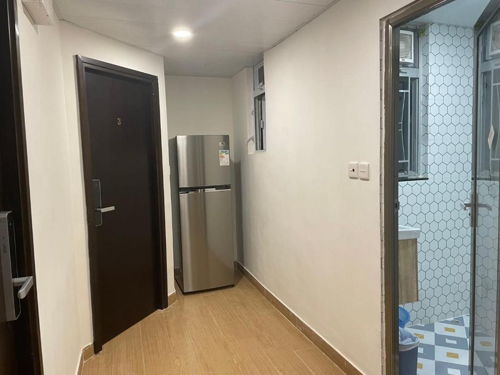 une chambre vide avec un réfrigérateur et une porte dans l'établissement Timehouse Hong Kong Hostel Group, à Hong Kong