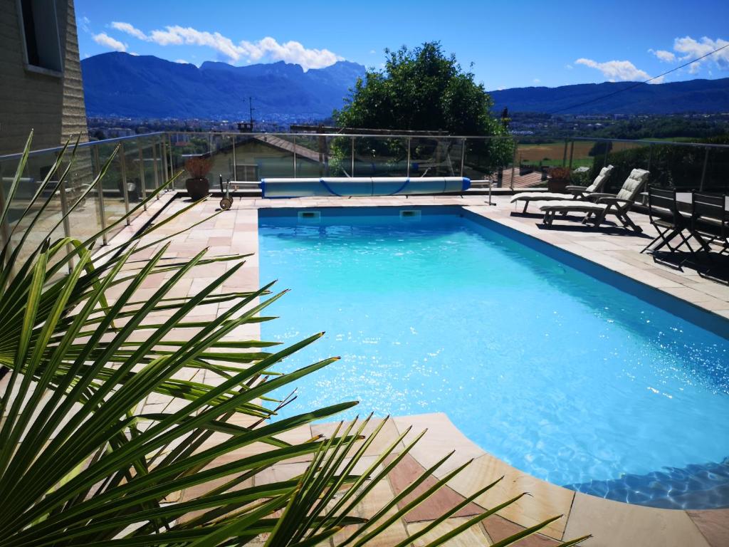a swimming pool with mountains in the background at Studio Bellevue indépendant rénové janvier 2023 piscine parking proche centre Annecy in Poisy
