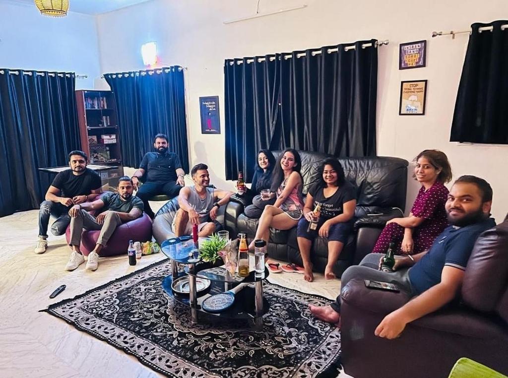 a group of people sitting on couches in a living room at Rostel Backpackers Hostel in Pune