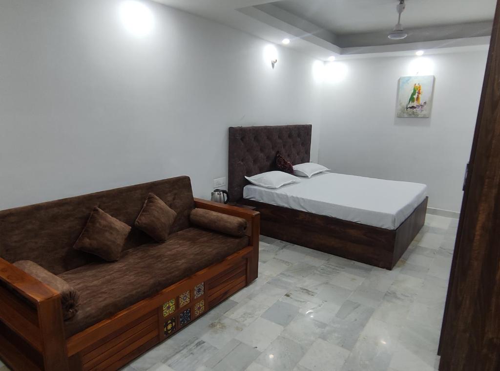 sypialnia z łóżkiem i kanapą w obiekcie Shanti Residency w Nowym Delhi