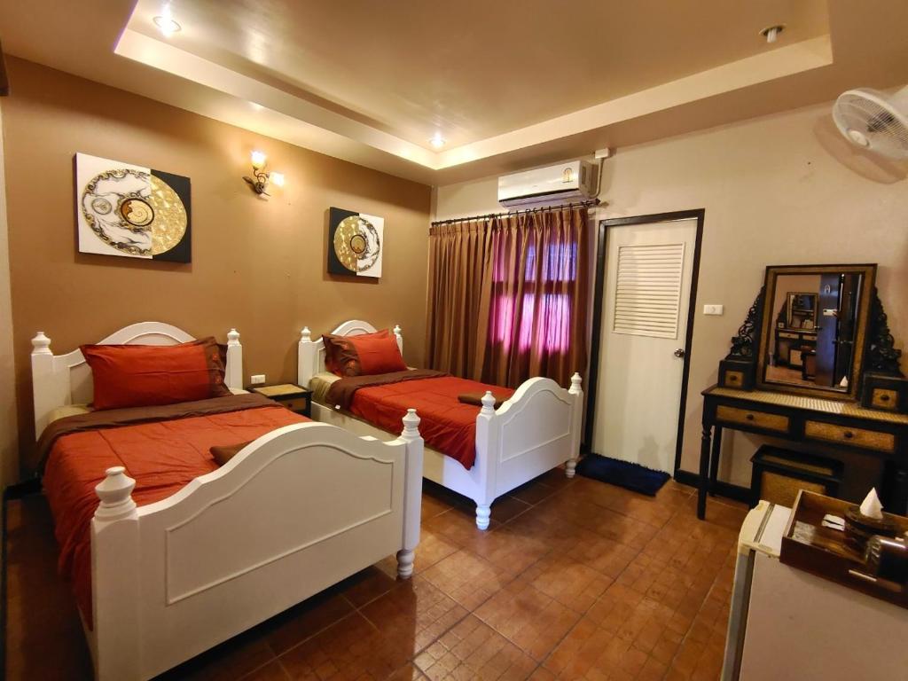 a bedroom with two beds and a window at Wualai Boutique by Lanna Oriental in Chiang Mai