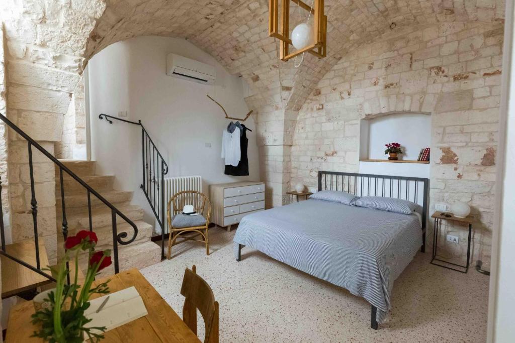 a bedroom with a bed and a stone wall at Da Concavo e Convesso in Locorotondo
