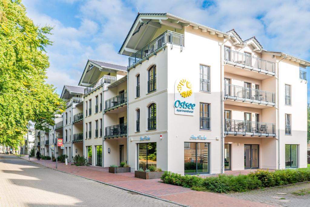 格拉爾－米里茨的住宿－Ostsee Apartmenthotel，一座白色的大建筑,上面有太阳标志