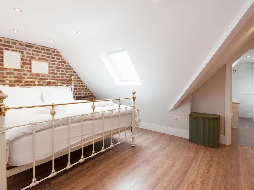 a bedroom with a bed and a brick wall at Bank Apartment 2 in Dartmouth