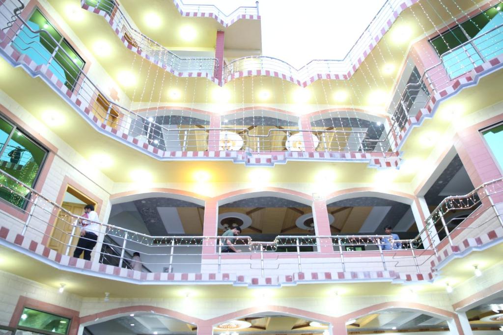 a large building with a balcony with people on it at Canari Hotel kashmir view in Nathia Gali