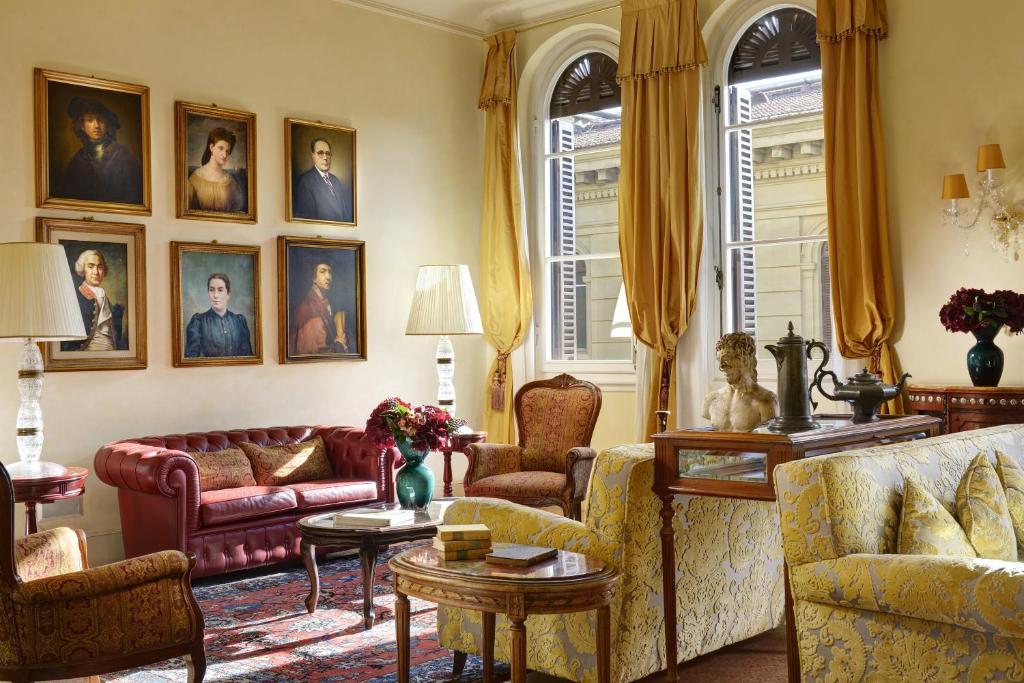 a living room with couches and portraits on the wall at Hotel Pendini in Florence