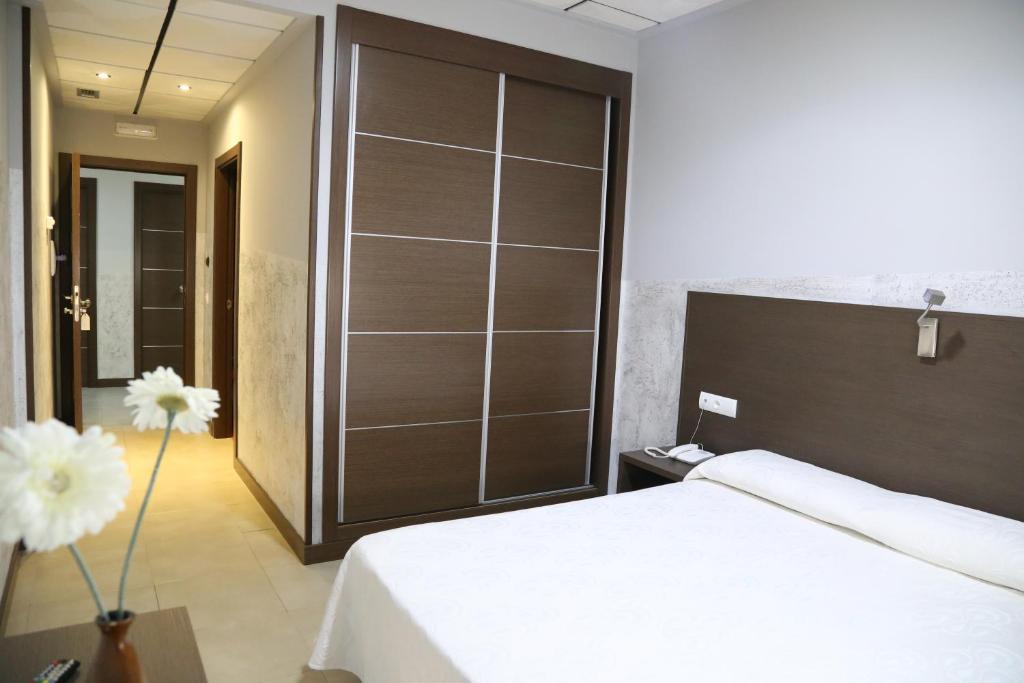 1 dormitorio con cama blanca y armario grande en Nuñez Tomelloso, en Tomelloso