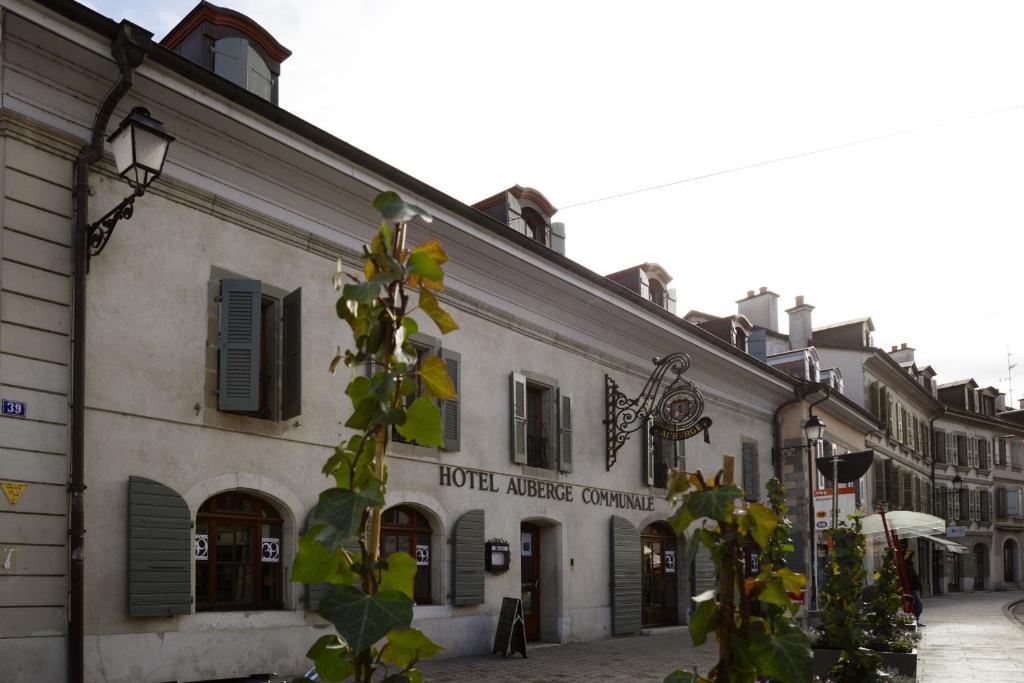 un bâtiment avec un panneau sur son côté dans l'établissement Auberge Communale de Carouge, à Genève