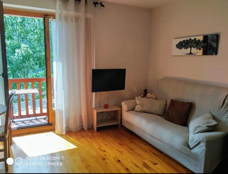 - un salon avec un canapé et une télévision dans l'établissement Apartamento en Boi, à Bohí