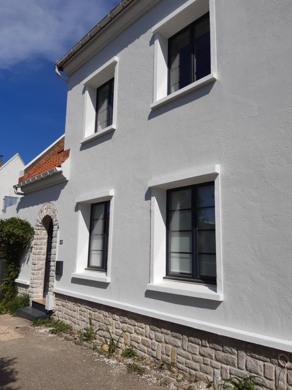 a white house with four windows on it at Maison de vacances-La balade des deux Caps in Audinghen