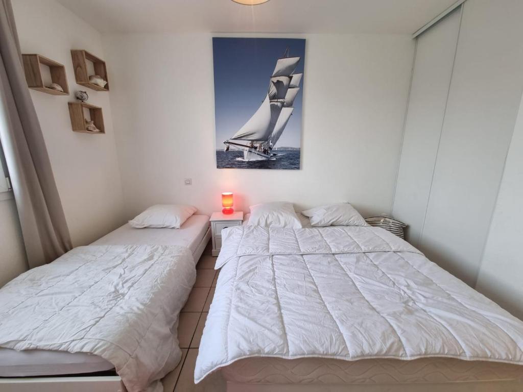 dwa łóżka w pokoju z obrazem na ścianie w obiekcie Villa confort et cosy 20 minutes d'Espagne w mieście Plage dʼArgelès