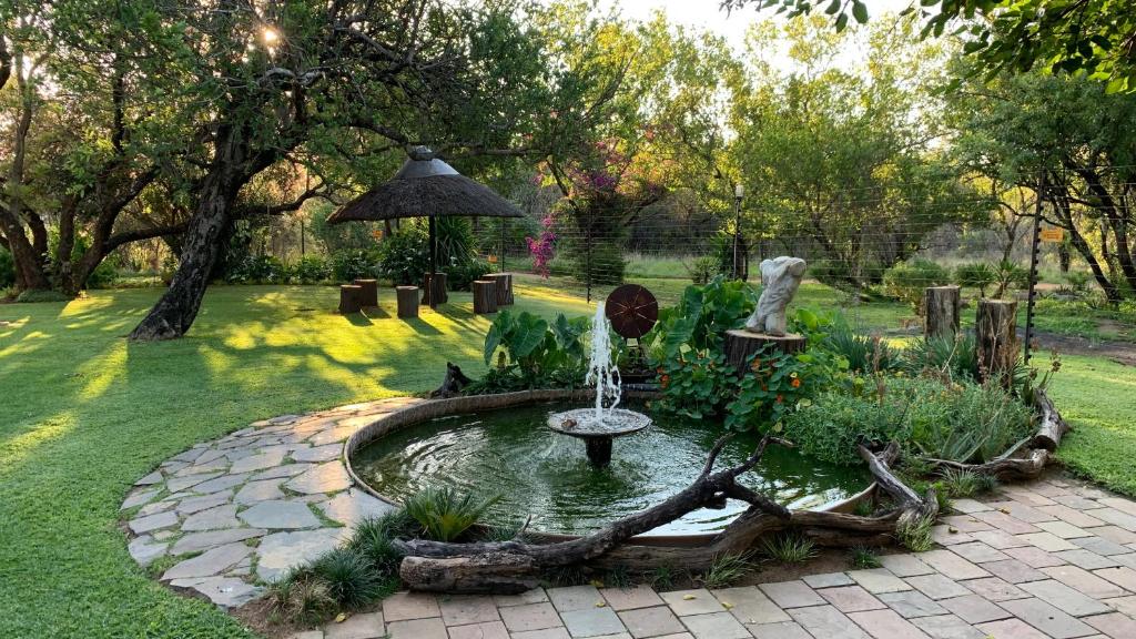 a fountain in the middle of a garden at OppiPlasie Guest House & SPA in Brits