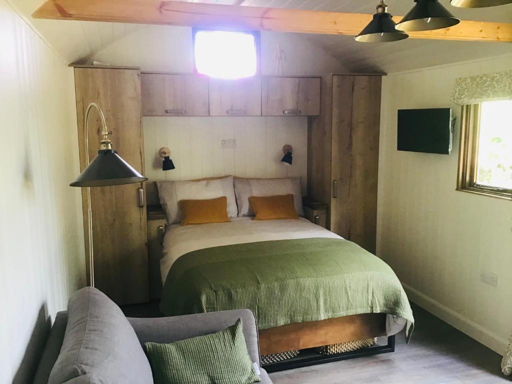 a bedroom with a bed and a couch at The Hut in the Orchard @ Yorecroft in Aysgarth