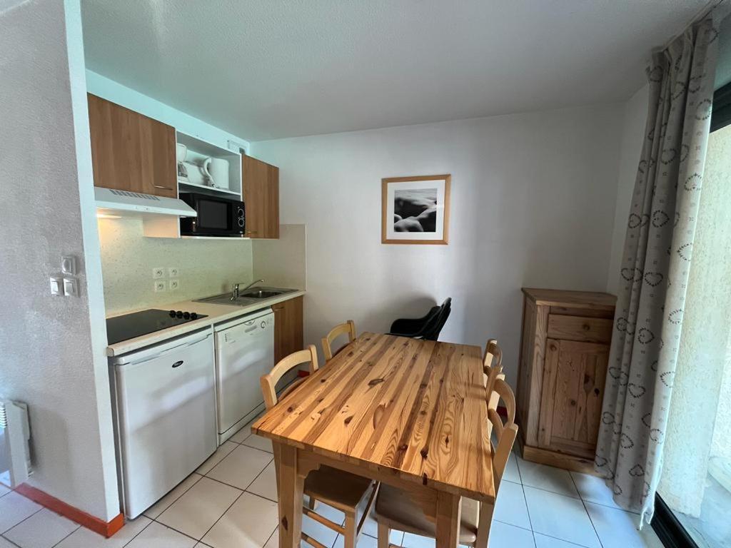 cocina con mesa de madera y sillas en Appartement Arreau, en Arreau