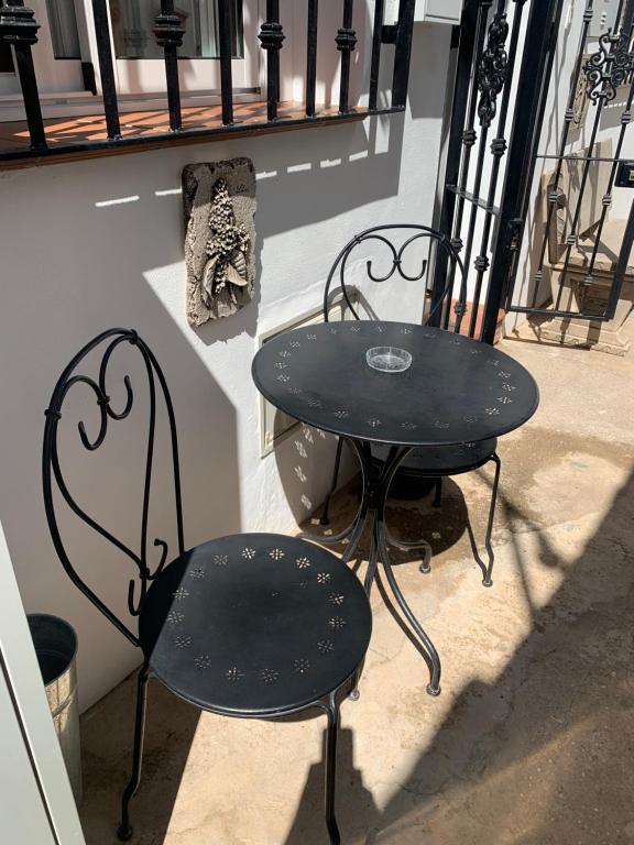 a black table and two chairs sitting next to a window at Torrox Pueblo Hidden Gem, 2 Bed Apartment in Torrox